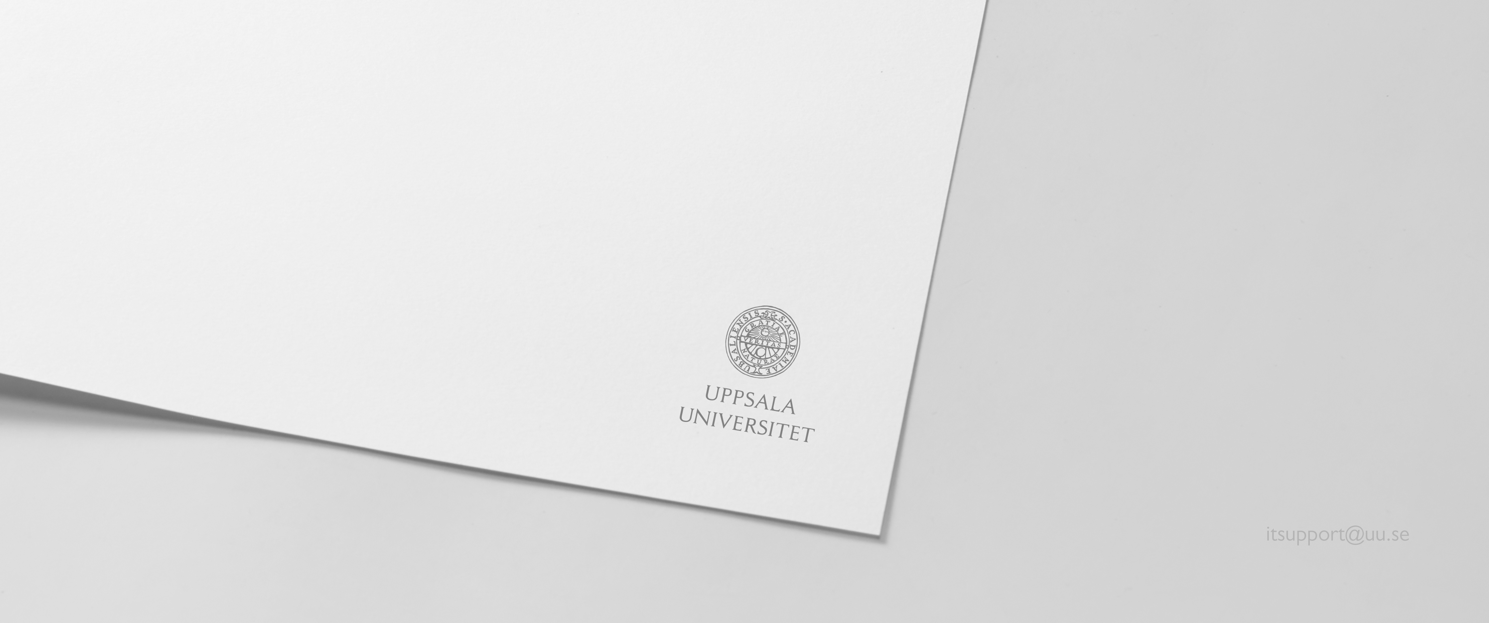Superbred bakgrundsbild med ett vitt papper med universitetets logotyp.