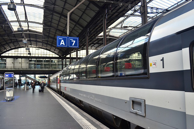 Bilden föreställer ett tåg vid en järnsvägsstation.