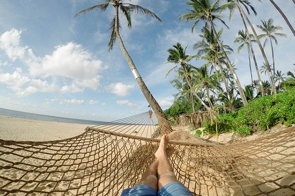 Person lying in a hammock with legs and feet visible